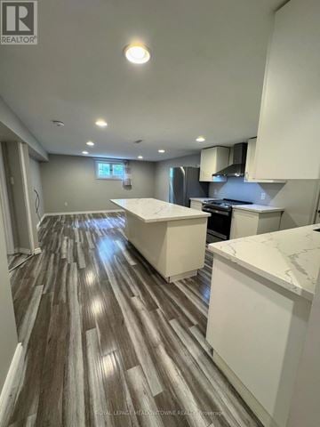 Halton Hills (Georgetown) apartment for rent - A kitchen with a white counter and wooden flooring.