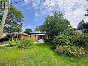 Halton Hills (Georgetown) apartment for rent - A house with a lawn and trees in front of it.