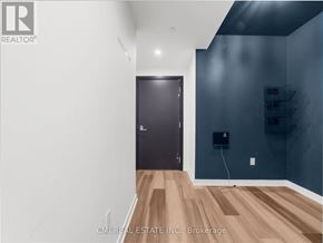 Kitchener condo for rent - A room with a dark brown door and a wooden floor.
