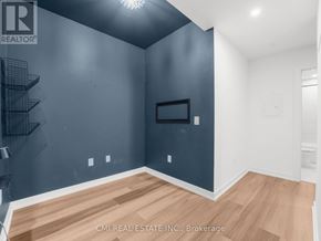 Kitchener condo for rent - A room with a wooden floor and a grey wall with a black framed window.