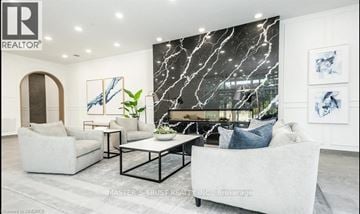 Guelph (St. Patrick's Ward) condo for rent - A living room with a white sofa, a black coffee table, and a large painting on the wall.
