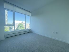 Surrey apartment for rent - A room with a large window and a carpeted floor.