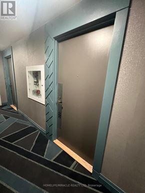 Hamilton (Kirkendall) condo for rent - A door with a peephole is in a room with a black and white tiled floor.