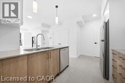 Kitchener townhouse for rent - A kitchen with wooden cabinets and a refrigerator.