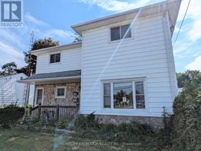 Oshawa (Samac) apartment for rent - A white house with a sign that says "HOMELIFE EXCELSIOR REALTY INC Brokerage".