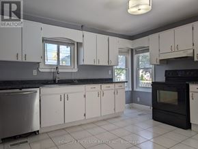 Oshawa (Samac) apartment for rent - A kitchen with white cabinets and black appliances.