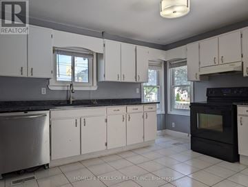 Oshawa (Samac) apartment for rent - A kitchen with white cabinets and black appliances.
