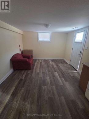 Brampton (Brampton East) apartment for rent - A room with a red chair and wooden flooring.
