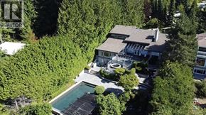 West Vancouver apartment for rent - A house with a pool surrounded by trees.
