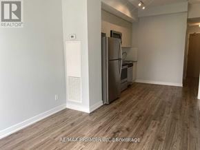 Toronto (Bayview Village) condo for rent - A kitchen area with a refrigerator and a stove top oven.