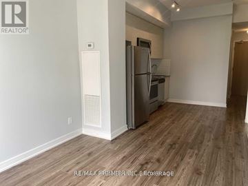 Toronto (Bayview Village) condo for rent - A kitchen area with a refrigerator and a stove top oven.