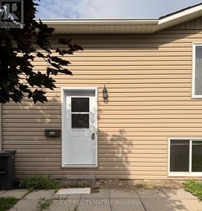 Russell apartment for rent - A beige house with a white door and a mailbox on the side.