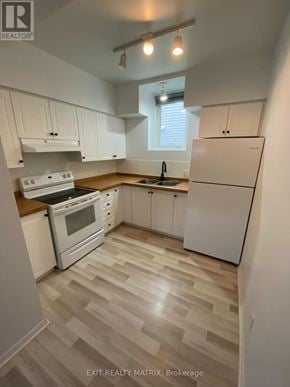 Russell apartment for rent - A kitchen with white appliances and wooden floors.