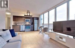 Toronto (Lansing-Westgate) condo for rent - A modern living room with a grey couch and a flat screen TV.
