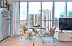 Toronto (Lansing-Westgate) condo for rent - A modern kitchen with a glass table and chairs, a refrigerator, and a television.