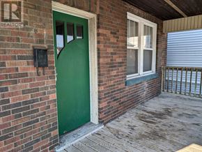 Oshawa (O'neill) apartment for rent - A green door is on the left side of a brick building.