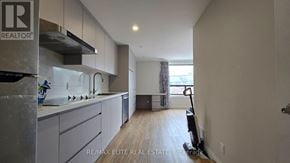 Toronto (Mimico) apartment for rent - A modern kitchen with a stove top oven and a vacuum cleaner.