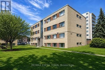 Burlington (Brant) condo for rent - A large, modern building with a green lawn in front.