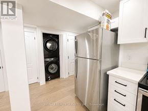 Brampton (Heart Lake West) apartment for rent - A kitchen with a stainless steel refrigerator and a washer and dryer stacked in the corner.