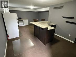 Maple Ridge apartment for rent - A kitchen area with a white refrigerator, a table with chairs, and a countertop.