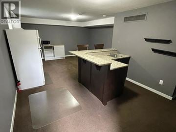 Maple Ridge apartment for rent - A kitchen area with a white refrigerator, a table with chairs, and a countertop.