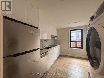 Toronto (Mimico) apartment for rent - A modern kitchen with a washing machine in the corner.