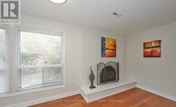 Toronto (Hillcrest Village) townhouse for rent - A living room with a fireplace and two paintings on the wall.