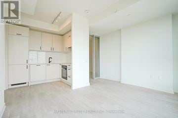 Toronto (Banbury-Don Mills) condo for rent - A spacious kitchen with white cabinets and a wooden floor.