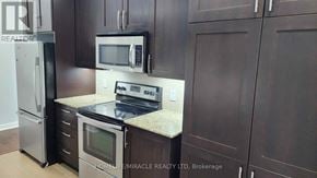 Mississauga (City Centre) condo for rent - A kitchen with dark brown cabinets and a granite countertop.