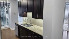 Mississauga (City Centre) condo for rent - A kitchen with dark brown cabinets and a granite countertop.