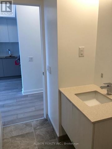 Toronto (Moss Park) condo for rent - A bathroom with a sink and a doorway leading to a kitchen.