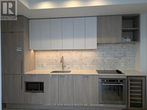 Toronto (Humewood-Cedarvale) condo for rent - A modern kitchen with wooden cabinets and a marble backsplash.