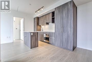 Toronto (Annex) condo for rent - A modern kitchen with wooden cabinets and a stainless steel oven.