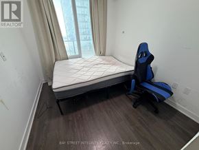 Toronto (Waterfront Communities) condo for rent - A bedroom with a bed, chair and window.