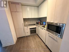 Toronto (Waterfront Communities) condo for rent - A kitchen with white cabinets and stainless steel appliances.