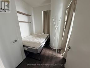 Toronto (Waterfront Communities) condo for rent - A small bedroom with a bed, a window, and a door.