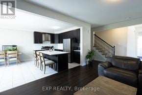 Ottawa apartment for rent - A modern kitchen with black cabinets and a dining table with chairs.