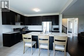 Ottawa apartment for rent - A kitchen with black cabinets and a dining table with four chairs.