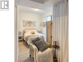 Toronto (Waterfront Communities) condo for rent - A bedroom with two beds and a nightstand with a lamp.