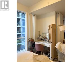 Toronto (Waterfront Communities) condo for rent - A bedroom with a desk and chair in front of a window.