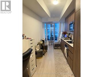 Toronto (Waterfront Communities) condo for rent - A well-lit kitchen with wooden cabinets and a large window.