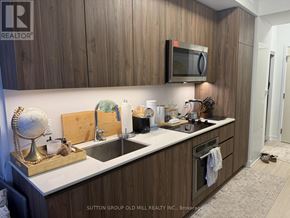 Toronto (Waterfront Communities) condo for rent - A kitchen with wooden cabinets and a white countertop.