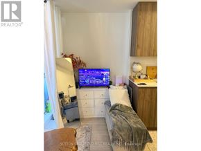 Toronto (Waterfront Communities) condo for rent - A bedroom with a bed, a desk, and a television displaying a map.