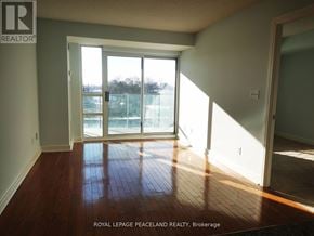 Toronto (Willowdale East) condo for rent - A room with wooden floors and a sliding glass door leading to a balcony.
