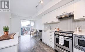 Toronto (Waterfront Communities) condo for rent - A modern kitchen with white cabinets and a view of the city.