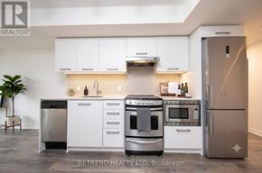 Toronto (Waterfront Communities) condo for rent - A modern kitchen with white cabinets and stainless steel appliances.