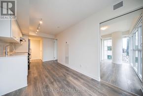 Toronto (Waterfront Communities) condo for rent - A spacious room with wooden flooring and white walls, with a large mirror on the wall.