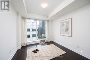 Toronto (Waterfront Communities) condo for rent - A room with a large window and a view of a city skyline.