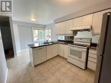 Mississauga (Central Erin Mills) townhouse for rent - A kitchen with white cabinets and appliances, including a refrigerator, oven, and microwave.