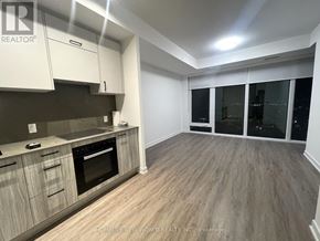 Toronto (Banbury-Don Mills) condo for rent - A kitchen with wooden floors and white cabinets.